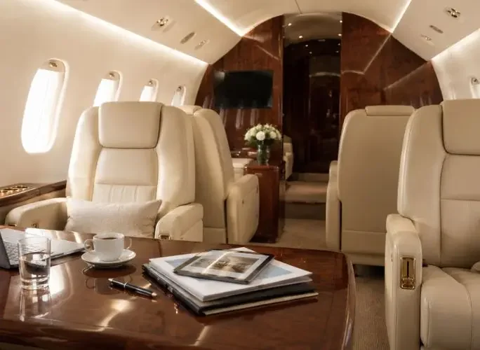 Luxurious private jet cabin with cream leather seats, walnut wood finishes, and a polished table set for work and relaxation — perfect for Diwali celebrations aloft
