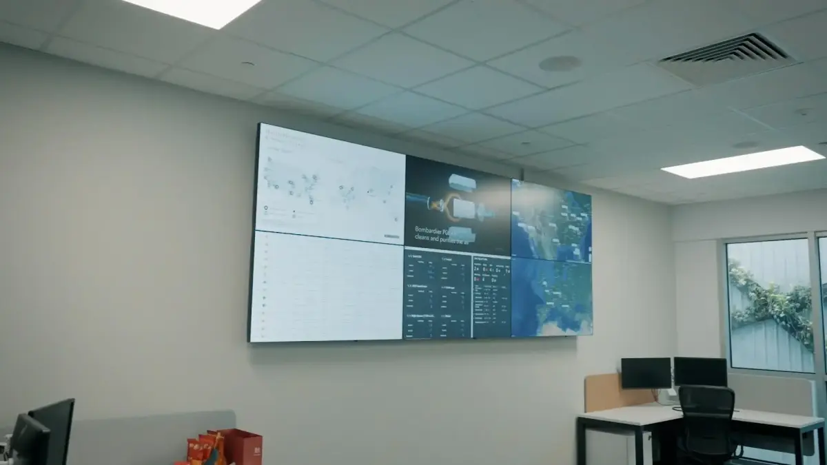Modern office conference room with large wall-mounted displays showing flight tracking data and aircraft information during VIP networking event