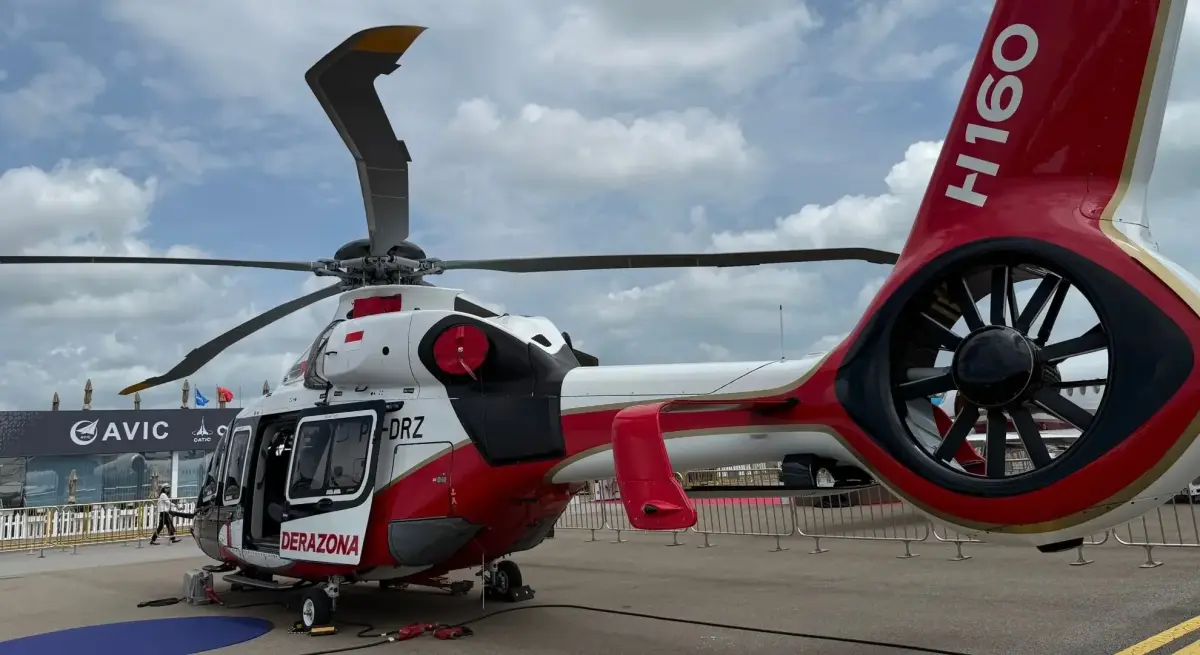 Modern red and white helicopter on display at aviation trade show showcasing latest rotorcraft technology
