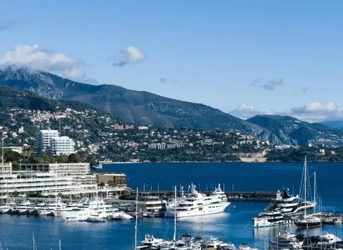 Luxury superyachts moored in Monaco harbour with the Monaco Yacht Show backdrop
