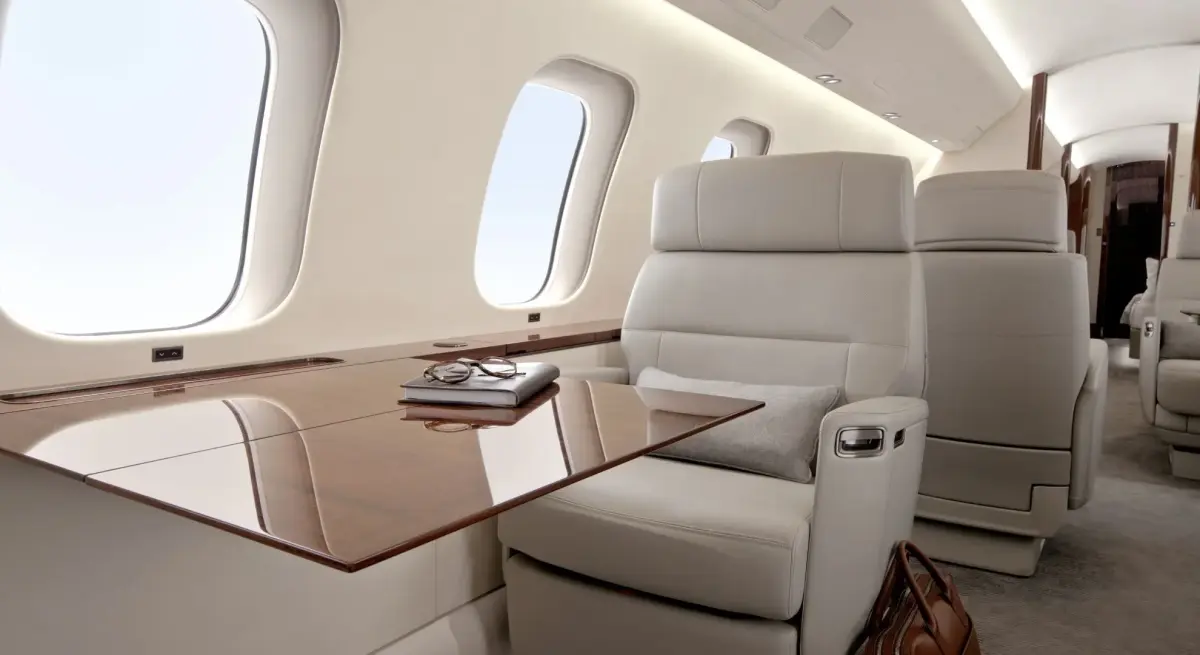 Spacious private jet cabin with leather recliner seats and large oval windows on a Jakarta to Batulicin charter flight