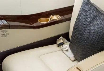Private jet cabin interior detail showing premium leather seat, highlighting onboard comfort unavailable in business class