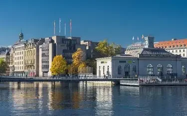 Scenic waterfront view of Geneva and its architecture buildings illustrating private jet travel from and to Geneva