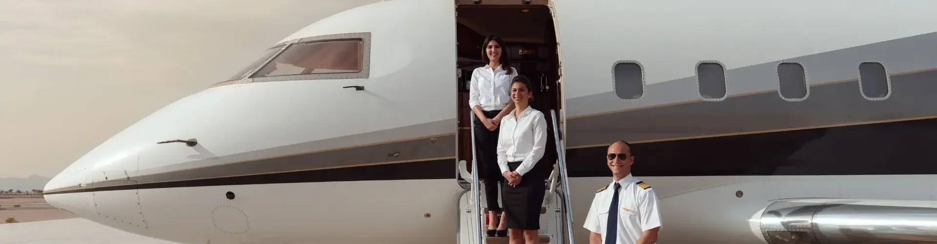 Best Private Jets for Different Types of Travel in Indonesia Private jet crew standing at the airstairs of a business jet on the tarmac for a private charter flight in Indonesia
