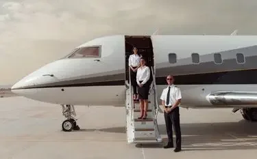 Best Private Jets for Different Types of Travel in Indonesia Private jet crew standing at the airstairs of a business jet on the tarmac for a private charter flight in Indonesia