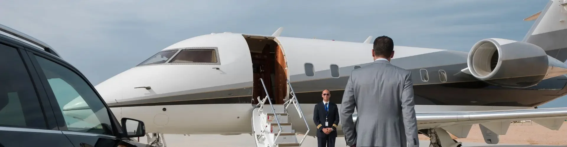 Business traveller walking toward a private jet, greeted by a crew member for a mining charter flight in Indonesia