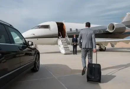 Business traveller walking toward a private jet, greeted by a crew member for a mining charter flight in Indonesia