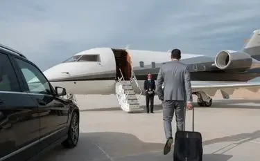 Business traveller walking toward a private jet, greeted by a crew member for a mining charter flight in Indonesia