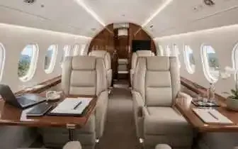 Private jet cabin interior with cream leather seats, wood finishes, and a work-ready table setup ideal for Indonesia travel