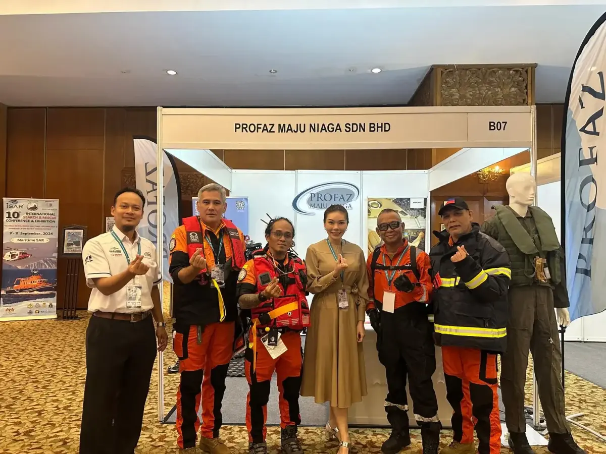 Professional team posing at aviation conference booth showcasing maritime search and rescue equipment