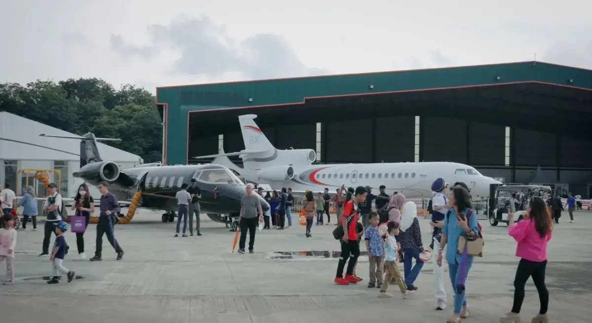 Visitors exploring luxury private jets displayed at aviation showcase event highlighting industry milestones