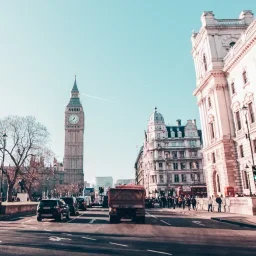 Big Ben clock tower and historic London architecture viewed from busy street with classic cars