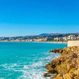 Stunning Mediterranean coastline of Nice with turquoise waters and rocky cliffs under clear blue sky