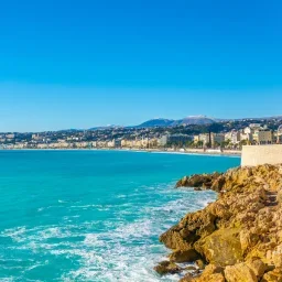 Stunning Mediterranean coastline of Nice with turquoise waters and rocky cliffs under clear blue sky