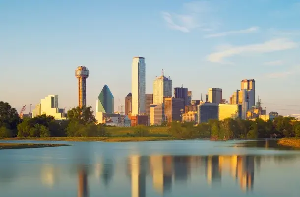 Dallas skyline at golden hour with iconic skyscrapers reflecting in Trinity River waters