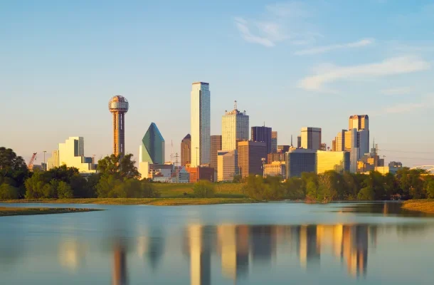 Dallas skyline at golden hour with iconic skyscrapers reflecting in Trinity River waters