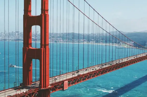 Golden Gate Bridge spanning San Francisco Bay with red towers and suspension cables over blue waters