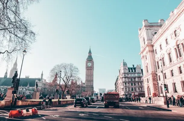 Big Ben clock tower and Westminster architecture in London with busy street traffic and pedestrians