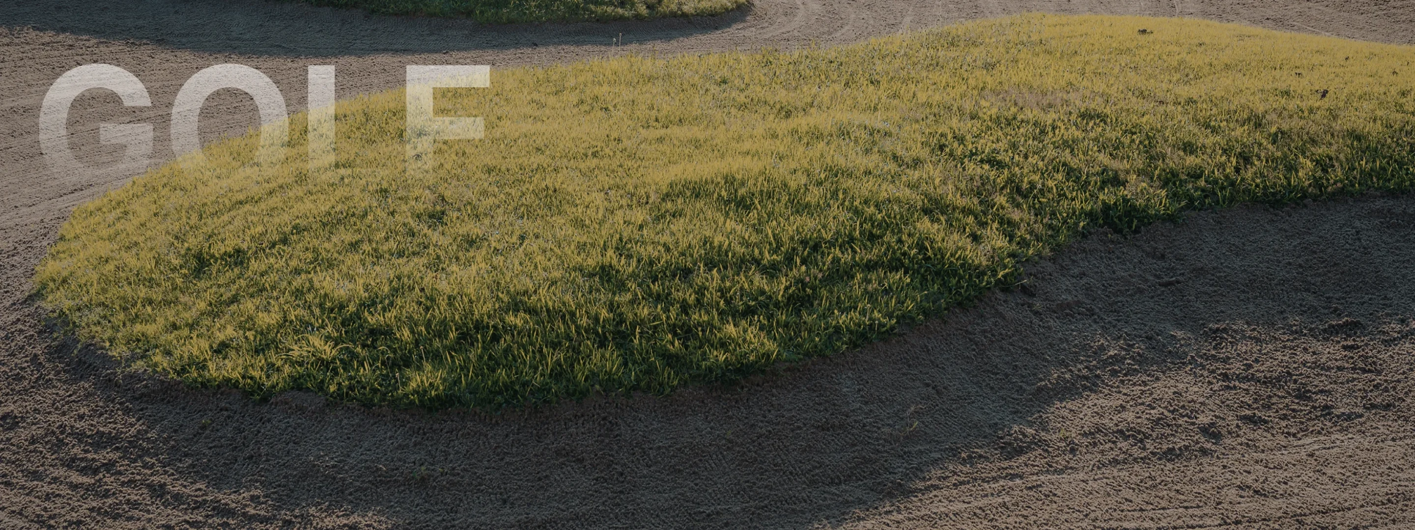 Golden hour sunlight illuminates pristine golf course fairway with natural grass bunkers at Bandon Dunes