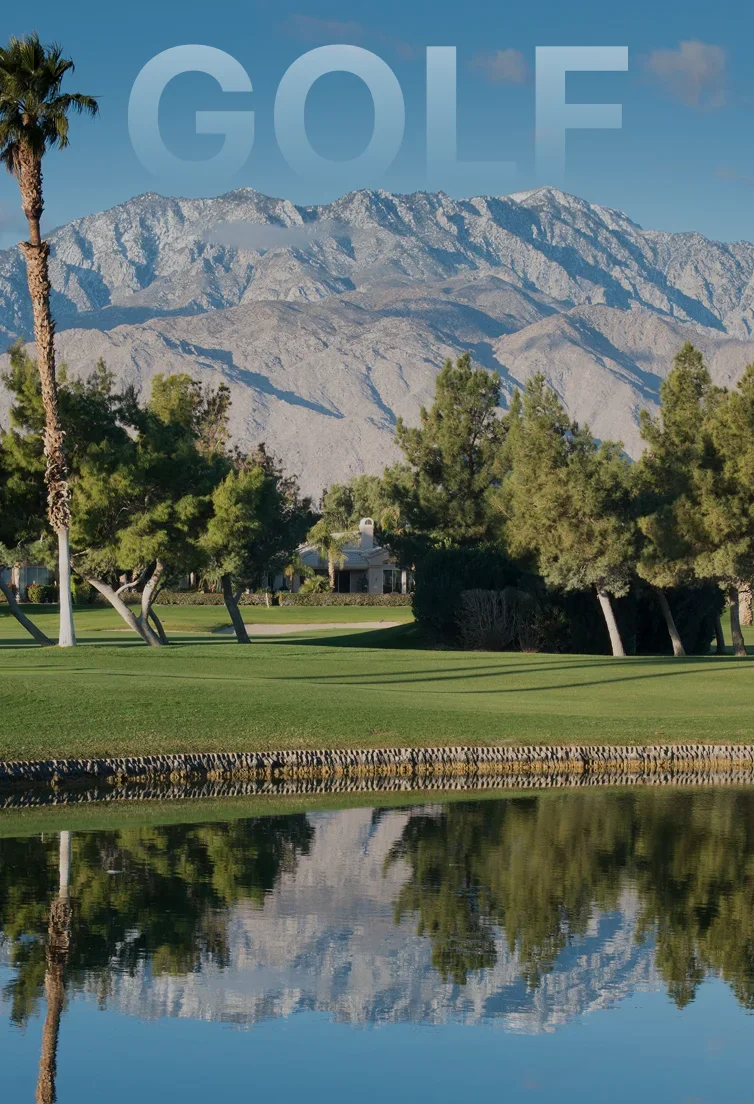Pristine golf course with manicured greens and palm trees against dramatic snow-capped mountains in Palm Springs