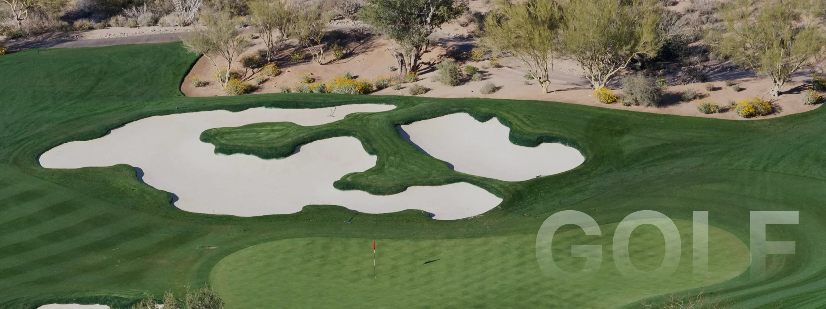 Aerial view of pristine Scottsdale golf course with manicured greens, sand bunkers and desert landscape