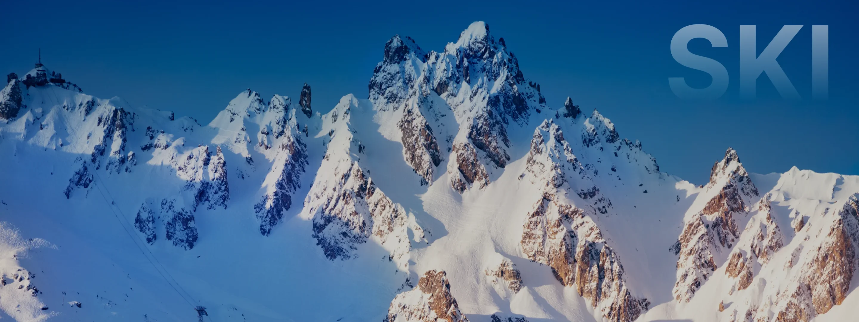 Snow-covered mountain peaks and alpine ridges under clear blue skies in Sun Valley ski destination
