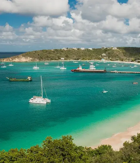 Pristine turquoise waters and white sand beach of Anguilla with luxury yachts anchored in protected bay