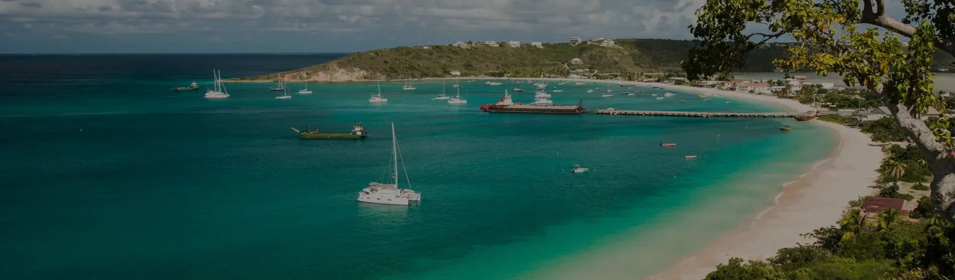 Pristine turquoise waters and white sand beach of Anguilla with luxury yachts anchored in protected bay
