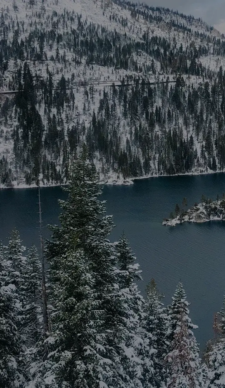 Snow-covered Lake Tahoe surrounded by pristine alpine forests and mountain peaks, a premier ski destination