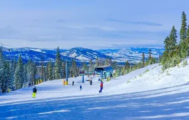 Pristine ski slopes at Vail with skiers descending powdery runs surrounded by snow-covered mountains