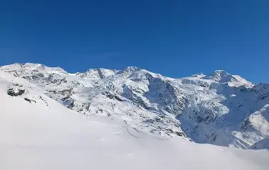 Snow-covered mountain peaks and pristine powder slopes under brilliant blue skies at Sun Valley ski resort
