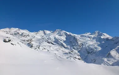 Snow-covered mountain peaks and pristine powder slopes under brilliant blue skies at Sun Valley ski resort