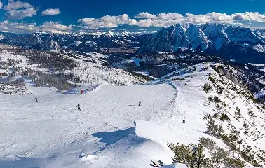 Aerial view of snow-covered ski slopes and mountain peaks in Park City with skiers descending pristine powder