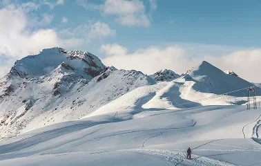 Snow-covered mountain peaks and pristine ski slopes under blue skies at Sun Valley resort