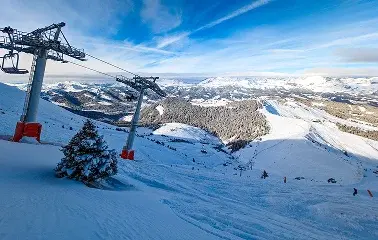 Ski lift gondolas ascending snowy mountain slopes with panoramic alpine views and pristine powder