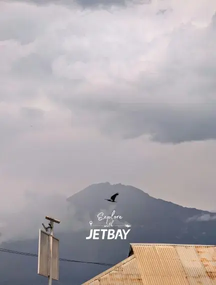 Dramatic cloudy sky over Mount Meru near Arusha, Tanzania with Jetbay branding for luxury travel exploration