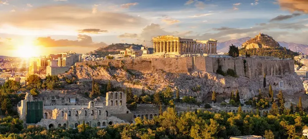 Golden sunset illuminates the ancient Acropolis and Parthenon temple overlooking Athens cityscape in Greece