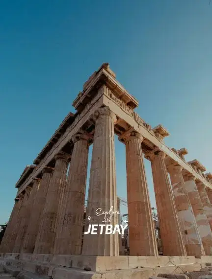 Ancient Parthenon temple with iconic Doric columns towering against clear blue sky in Athens, Greece