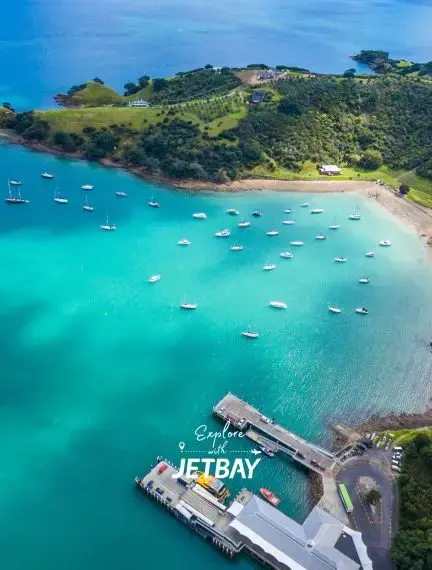Aerial view of turquoise waters and luxury yachts anchored in Auckland's pristine harbor bay