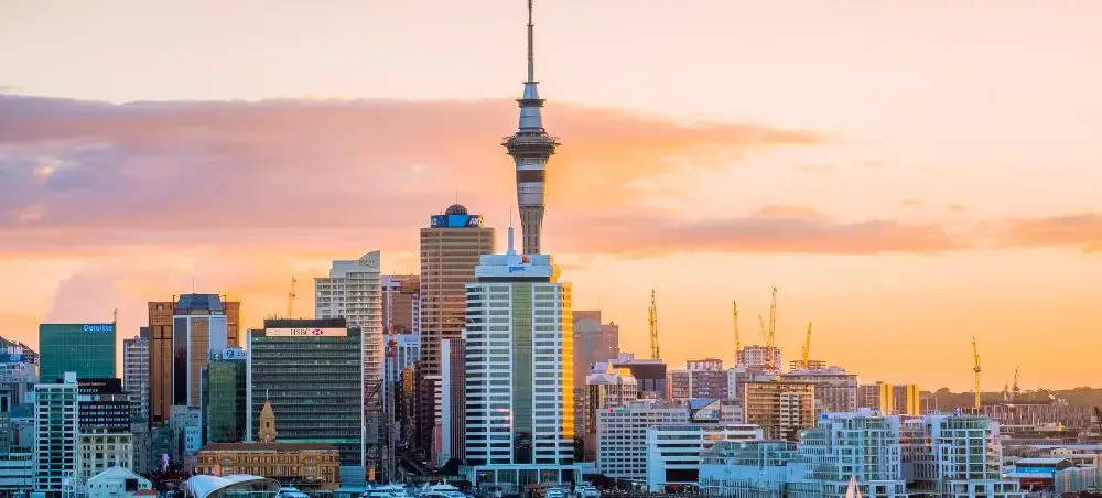 Auckland skyline featuring Sky Tower at sunset showcasing New Zealand's premier private jet destination
