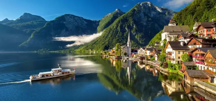 Scenic Austrian lakeside village with traditional alpine architecture nestled among snow-capped mountains