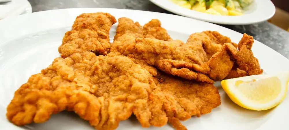 Golden-brown schnitzel served with lemon wedge showcasing Austria's renowned culinary traditions