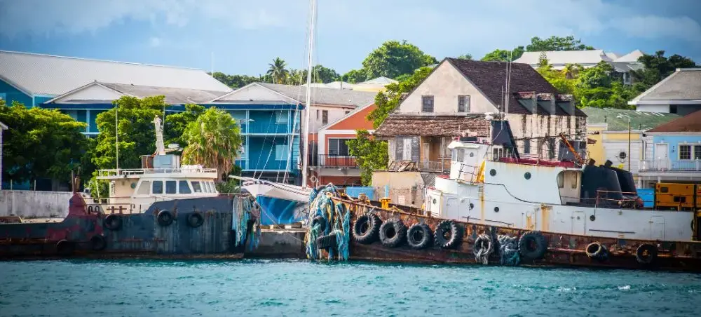 Colorful waterfront buildings and fishing boats in a Bahamian harbor showcase the islands' charm
