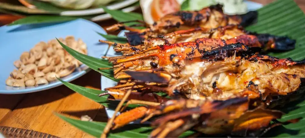 Grilled prawns with caramelized glaze served on banana leaves showcase authentic Balinese seafood cuisine
