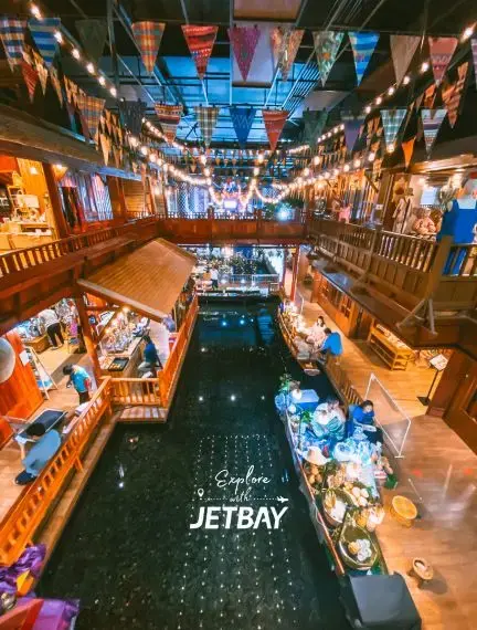Vibrant floating market in Bangkok with colorful bunting, wooden walkways, and traditional boats selling local goods