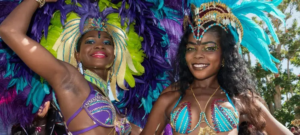 Vibrant carnival dancers in elaborate feathered costumes celebrate at Barbados festival with tropical flair