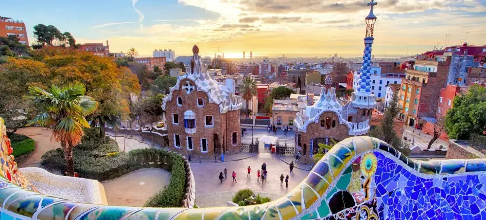 Panoramic view of Barcelona's Park Güell showcasing Gaudí's colorful mosaic architecture and city skyline