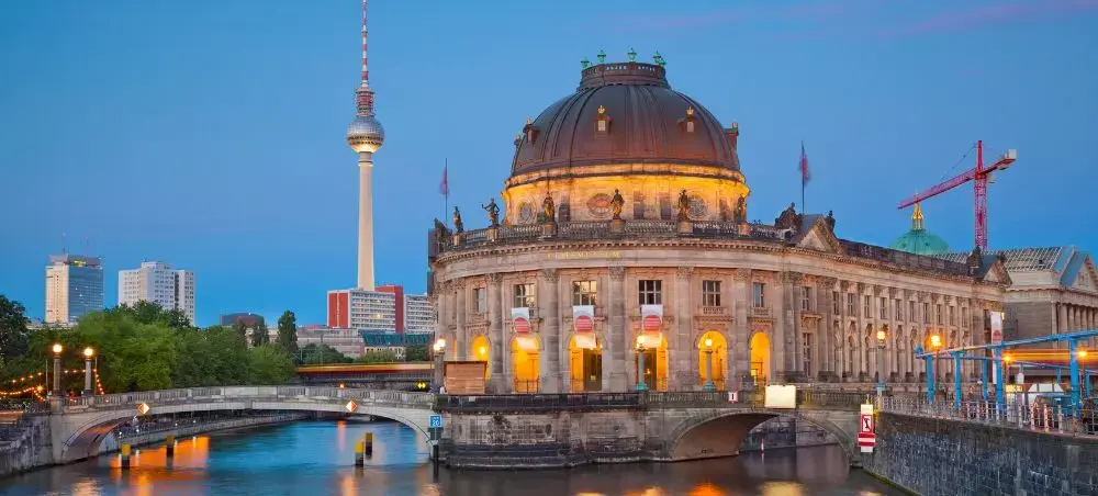 Berlin's illuminated Bode Museum and TV Tower create stunning twilight reflections on the Spree River