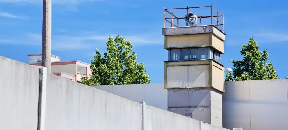 Historic Berlin Wall watchtower with concrete barriers showcasing the city's Cold War heritage