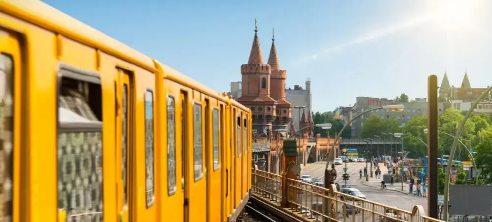 Yellow Berlin U-Bahn train crossing elevated tracks with historic Oberbaum Bridge towers in background